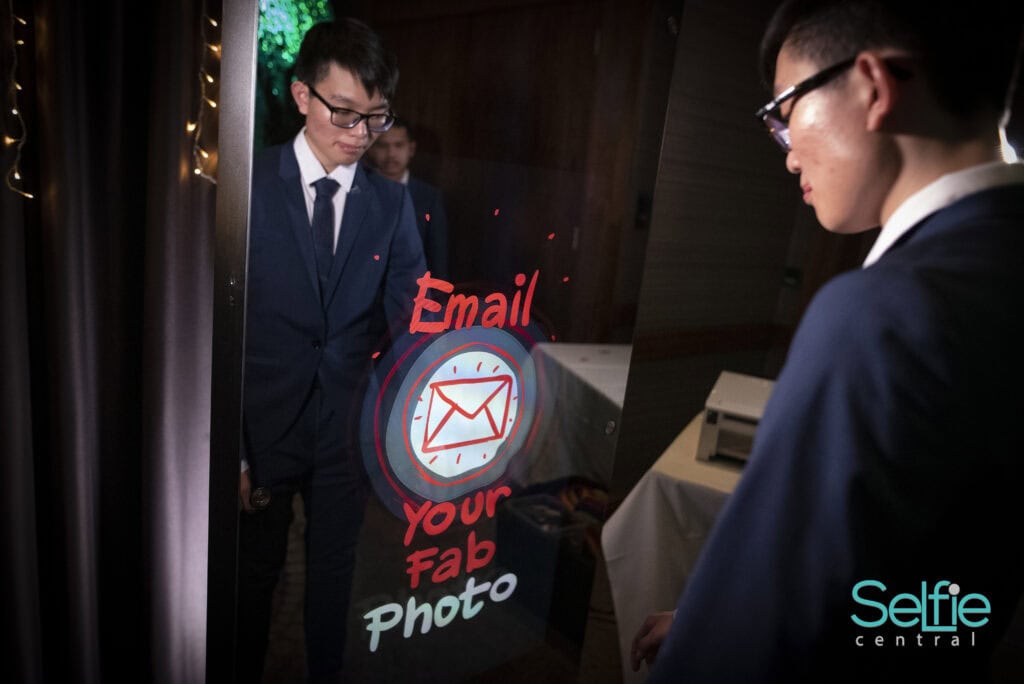 Guests using photo booth at Auckland event for fun and selfies.