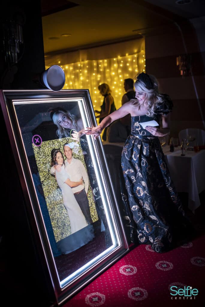 Woman using a selfie mirror at a photo booth event in Auckland.