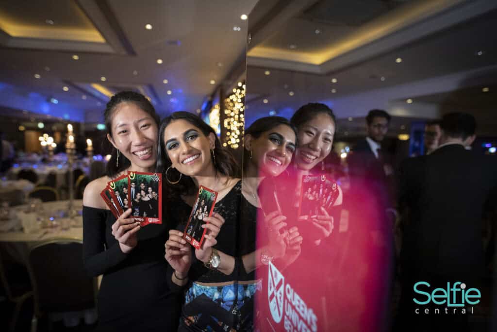 Group of friends using photo booth at Auckland event.
